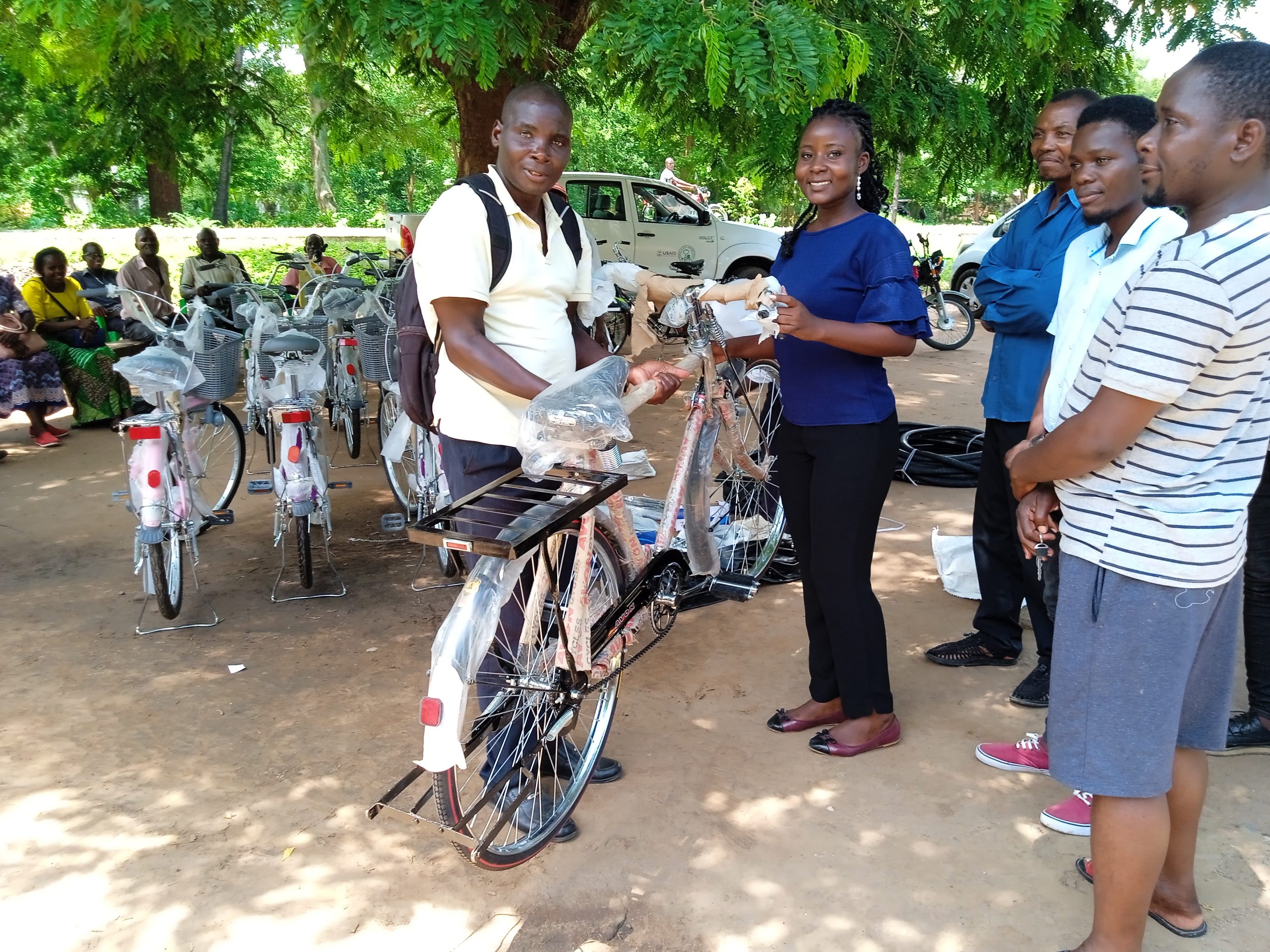 An Expert Client receiving a bicycle from an official from Nsanje district health office